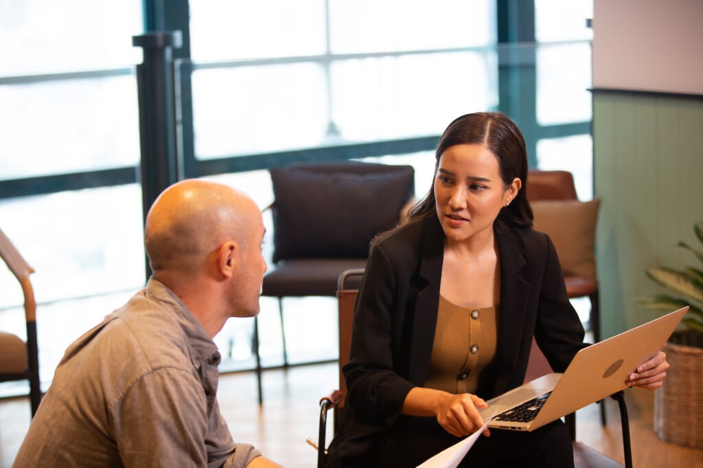 female business advisor holding terms sheets at a table with the tech founder